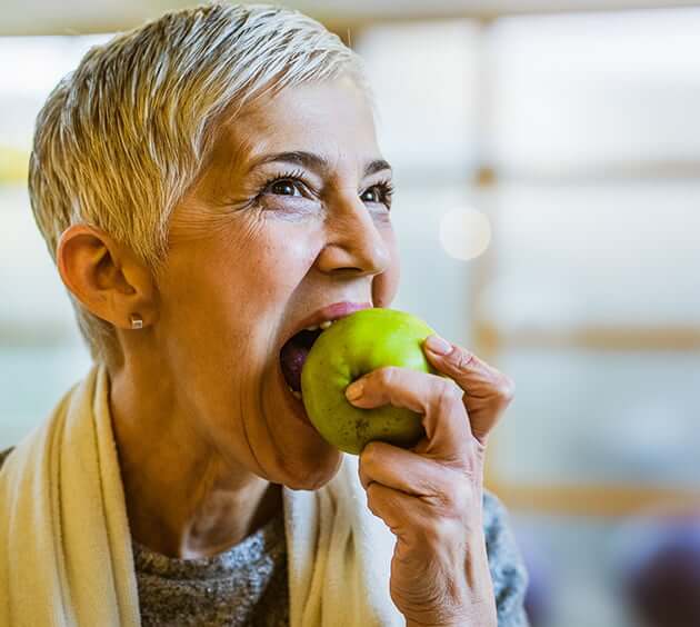 senior woman biting apple