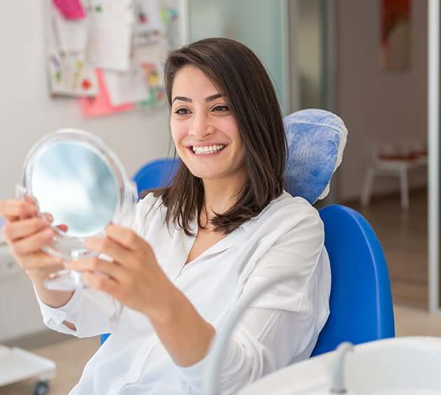 woman at the dentist looking at her smile