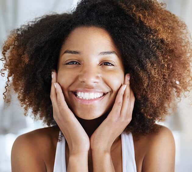 young woman holding face and smiling